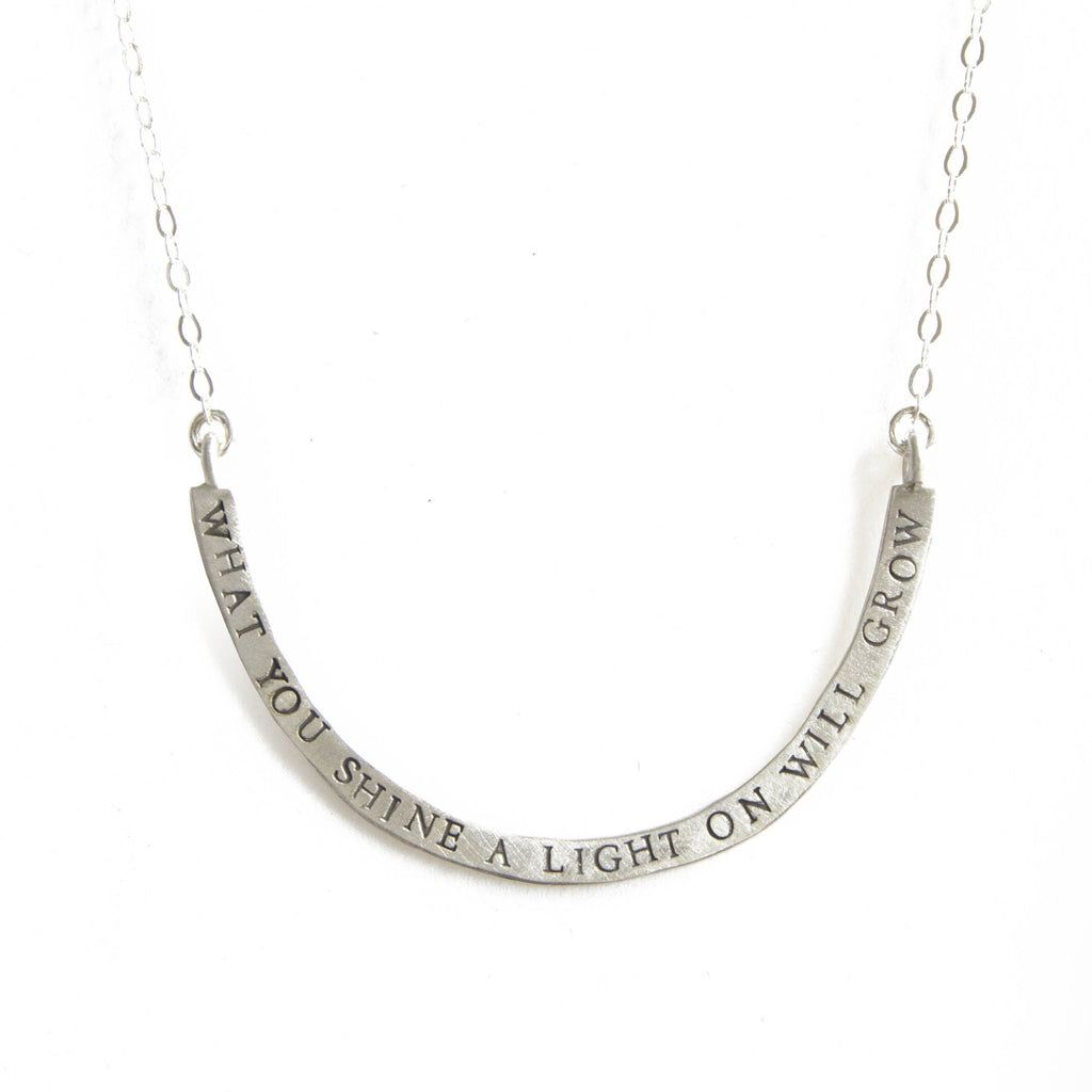 what you shine a light on cup half full necklace
